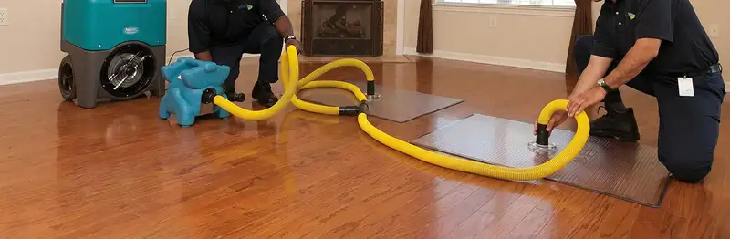 emergency water removal technicians extracting standing water from a home using professional equipment in Milwaukee, WI